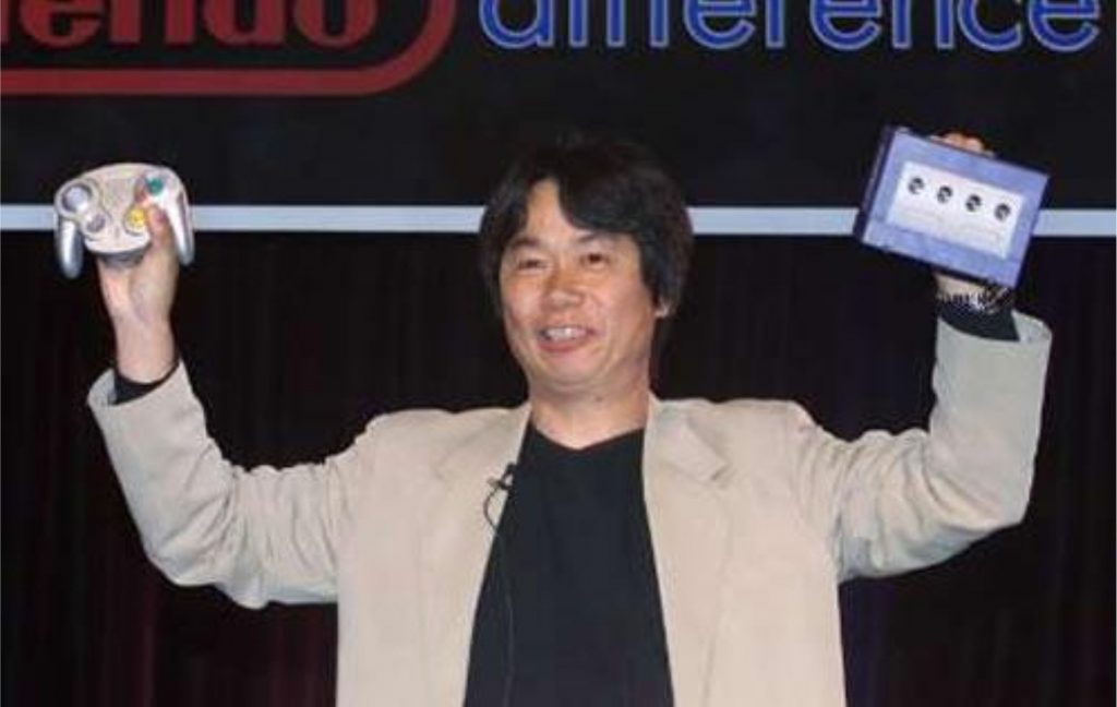 Miyamoto segurando um GameCube e um Wavebird