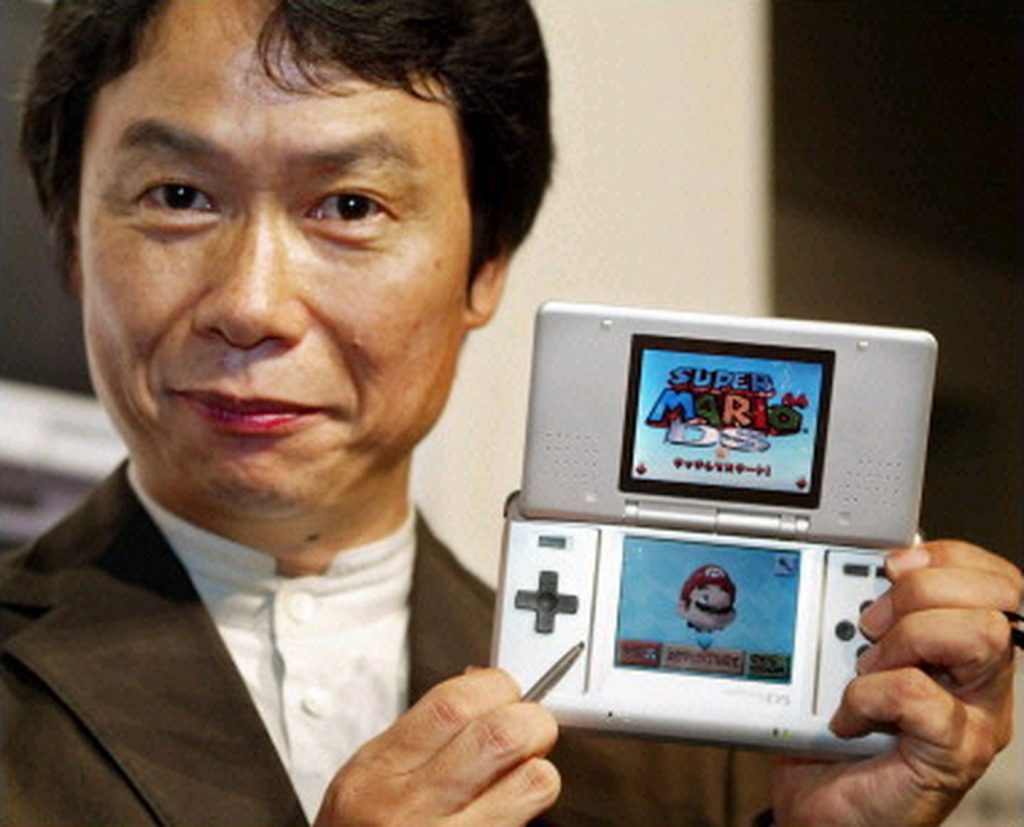 Miyamoto segurando o DS original, jogando Super Mario 64 DS 